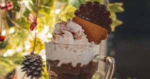 sfondo-albero-natale-primo-piano-cioccolata-calda-con-panna-e-biscotto