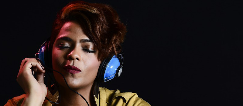 ragazza nera ascolta musica con cuffie azzurre