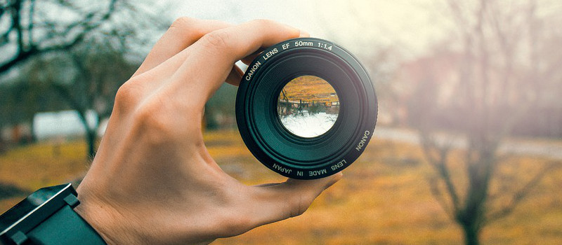 mano regge obiettivo macchina fotografica