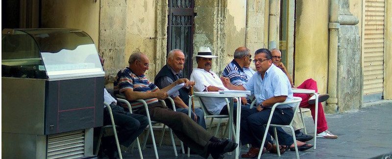 anziani parlano al bar seduti sui tavolini fuori