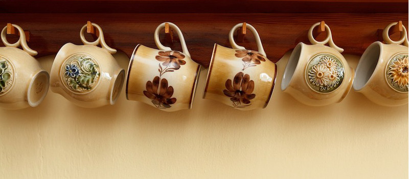 set di tazze nuance marrone con motivi appese al muro
